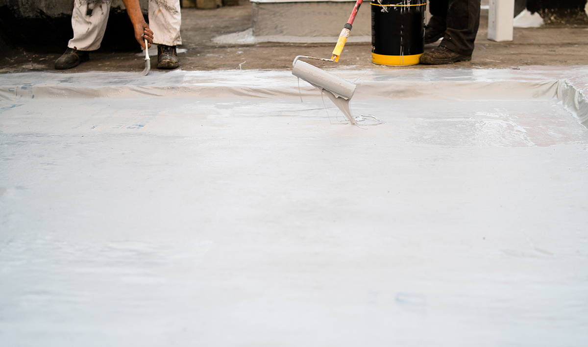 Common Commercial Roof Problems and How to Address Them 5 Roof Insulation, Two Man Applying Material Using The Paint Rolle